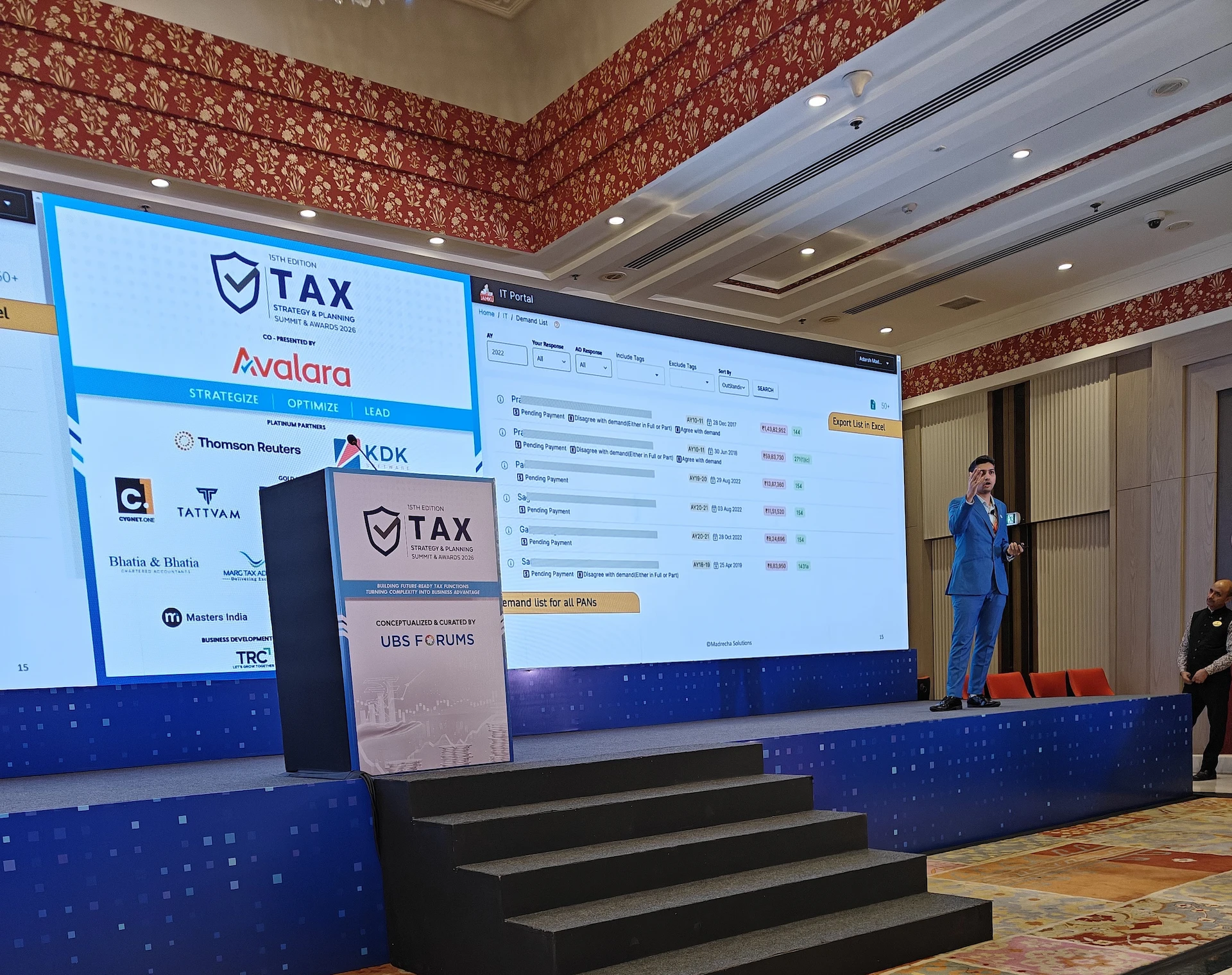 Speaker demonstrating a tax automation tool on stage at the award ceremony in Delhi, with TAX conference branding on screen